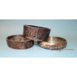 Three engraved silver hinged bangles, 75g.