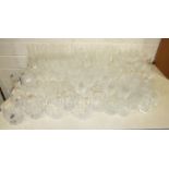 A large collection of cut-glass wine glasses, highball and other glasses, two art glass jugs and