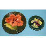 A Moorcroft circular shallow dish with hibiscus tubeline decoration on a green ground, 11.5cm