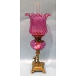 A Victorian brass column oil lamp, the column with winged cherub on square base and scroll feet,