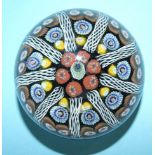 A millefiori glass paperweight, the symmetrical group of vertical multi-coloured canes divided by