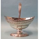 A George III silver sweetmeat basket, of oval form with ribbed swing handle, raised on oval pedestal
