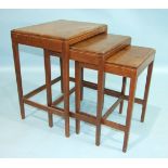 A nest of three rectangular hardwood tables on square tapered legs, each top with simple inlaid