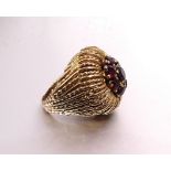 A large yellow metal rope-twist ring set a cluster of eight round-cut garnets, size I, 9.6g, (