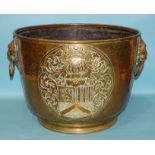 A large copper log box with applied coat of arms and lion mask handles, 51cm diameter, 38cm high,