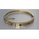 A Victorian sapphire and diamond hinged bangle, the front panel star-set with alternating round-
