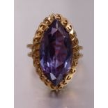 A gold dress ring claw-set synthetic purple sapphire, the mount bearing Middle Eastern marks for