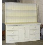 A 19th century painted pine dresser base, fitted with central drawer above a pair of cupboard