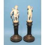 A pair of early-20th century Continental white metal-mounted serpentine columns surmounted by carved