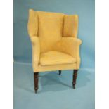 A Georgian mahogany wing tub chair, the upholstered high back raised on turned mahogany front legs