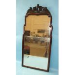 An 18th century small shaped yew wood wall mirror, with two bevelled plates surmounted by a carved