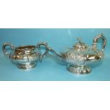 An Irish silver teapot and sugar bowl of lobed compressed form, with alternate panels embossed