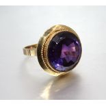 A large dress ring set round fancy-cut purple synthetic sapphire, in unmarked yellow gold mount,