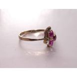 A ruby and diamond ring of asymmetric design set three oval rubies and one brilliant-cut diamond, in