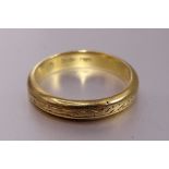 An 18ct gold wedding band with engraved decoration, size P, 5.1g.