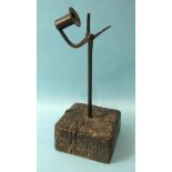 An antique iron table rush nip and candle holder, with wood block base, 28cm high.