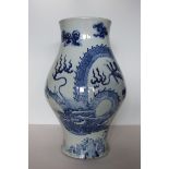 An unusual Chinese blue and white large bulbous jar decorated with a sinuous dragon chasing the