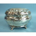 An Edwardian silver tea caddy of shaped oval form raised on four feet, 13cm wide, ___72.oz, (dents