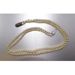 A necklace of two strings of graduated cultured pearls, 3.5-6mm diameter, with silver clasp, 39cm