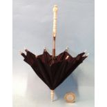 A miniature umbrella with turned bone handle, tips, fit-up and ferrule, with black silk canopy, 20cm