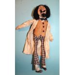 An amusing man-doll with knitted painted face, supercilious sneer, wool moustache and beard and wool