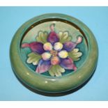 A Moorcroft small circular dish with columbine tubelined decoration on a green ground, impressed '