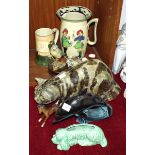 A Winstanley tabby cat with amber glass eyes, no.5, 34cm long, a Royal Doulton 'Musketeer' jug, 20.