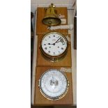 A Schatz aneroid barometer, a Stockburger bulkhead clock, a reproduction ship's bell, all mounted on