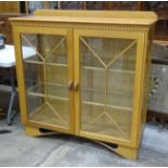 A craftsman-made oak display cabinet, the rectangular top above a pair of astragal-glazed doors,