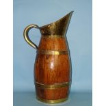 A late-19th/early-20th century oak and brass coopered barrel-shaped jug of large proportions, with