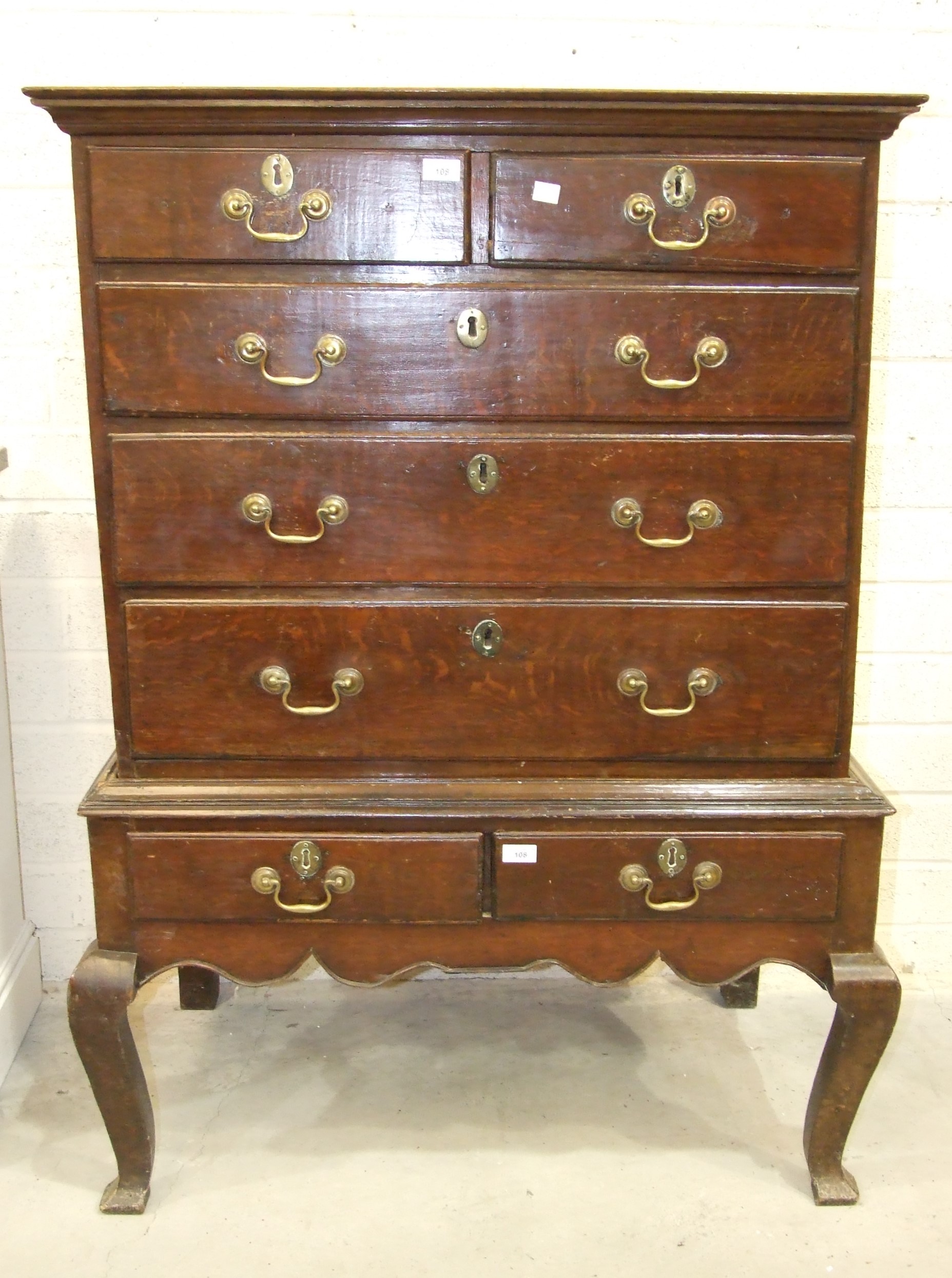 A Georgian oak chest on stand, the chest with two small and three long graduated drawers, the base