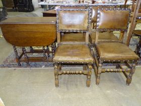 A set of four oak framed dining chairs with leather padded seats and backs and an oak drop-leaf