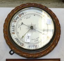 An aneroid barometer in oak rope-twist surround, 26.5cm diameter overall, a Foster Callear brass