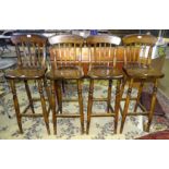 A set of four modern stained wood lathe-back bar/kitchen stools.