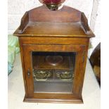An Edwardian oak smoker's cabinet, the interior fitted with pipe racks and two drawers, 39.5cm high,