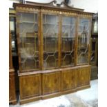 A modern yew wood breakfront bookcase fitted with four astragal-glazed doors above four base