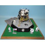 A Franklin Mint Apollo x1 Lunar Module with three figures and flag, on moonscape display stand