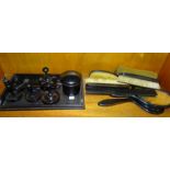 A collection of ebony dressing table items, including a hat pin stand, brushes, mirrors, etc, (n.