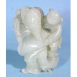 A Chinese carved jade figure of a man carrying a child, with a goat at his feet, 5cm high.