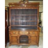 A Georgian oak dresser, the upper part with moulded cornice, above three shelves with iron cup