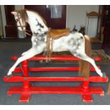 An Edwardian painted dapple grey rocking horse with horsehair tail and mane, leather reins and