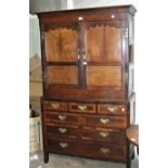 An antique oak cupboard, having a pair of panelled doors above seven drawers, 110cm wide, 190cm