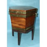 A George III brass-bound mahogany cellarette of hexagonal shape, with lift lid enclosing a lead-