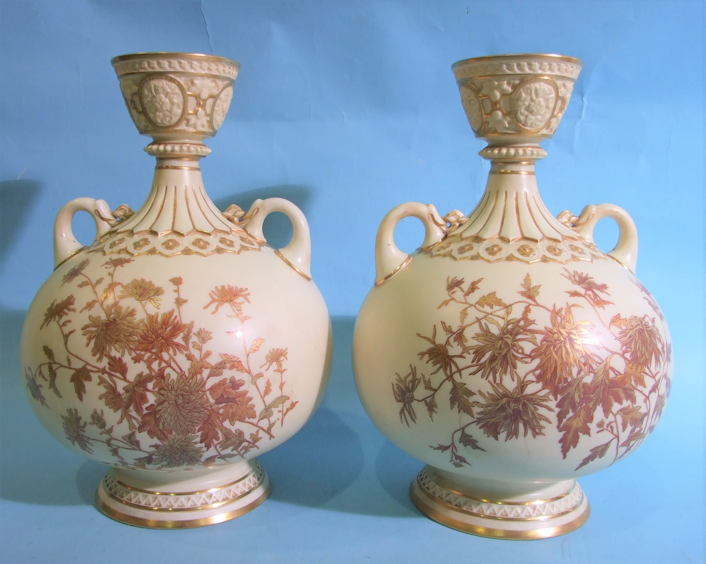 A pair of Royal Worcester baluster-shaped two-handled vases, having a cup neck with gilt floral