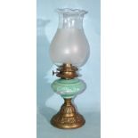 A late-19th/early-20th century oil lamp, the green opaque glass reservoir with white enamel floral