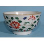 A Chinese Kang Hsi period famille verte tea bowl decorated with flowering lotus plants.