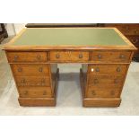 An Edwardian oak pedestal writing desk, the rectangular top with writing inset above three frieze