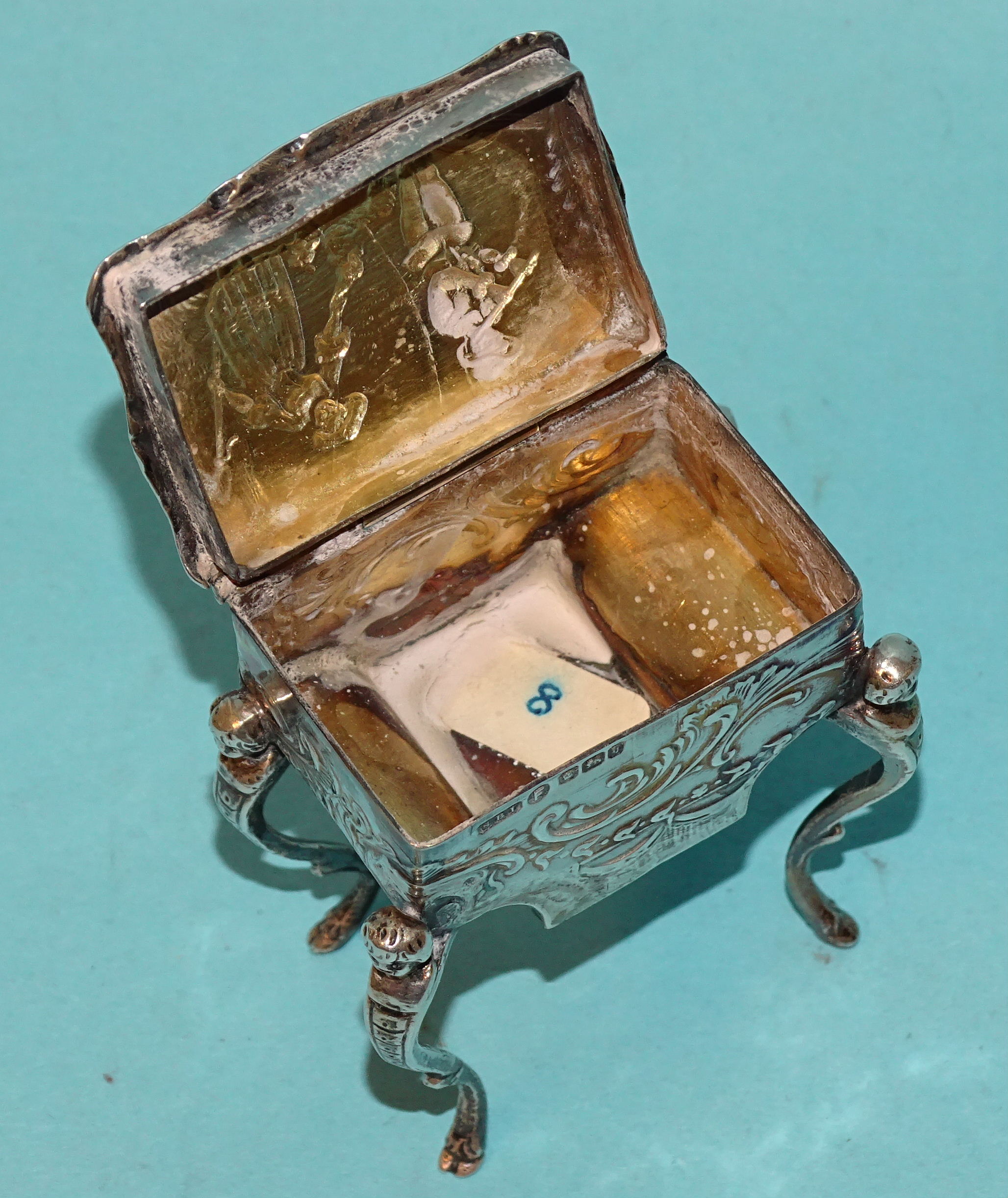 A Continental silver pill box in the form of a worktable, on cabriole legs, with embossed - Image 6 of 11