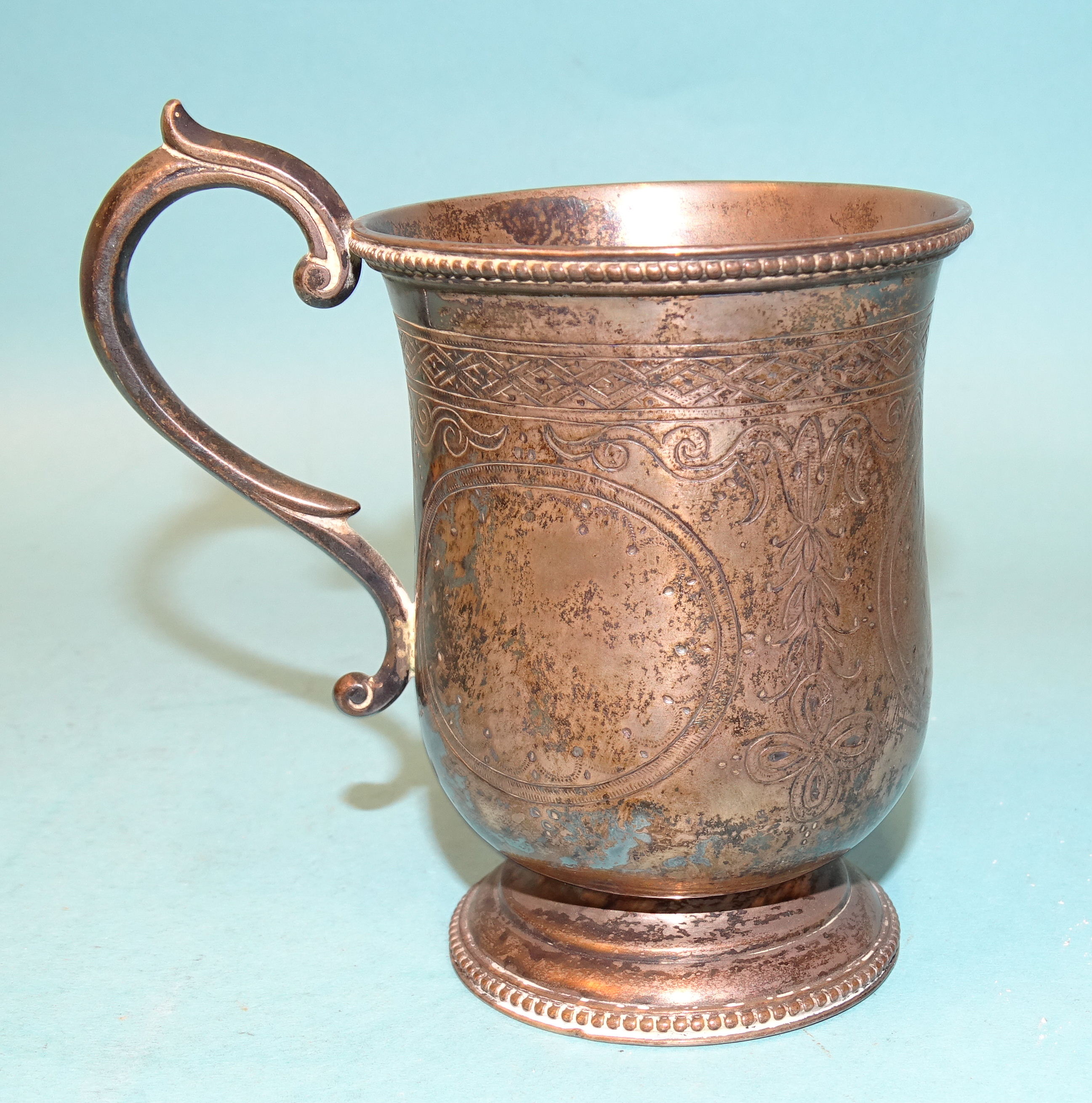 A white metal christening mug with engraved decoration and beaded border by P Orr & Sons, Madras,
