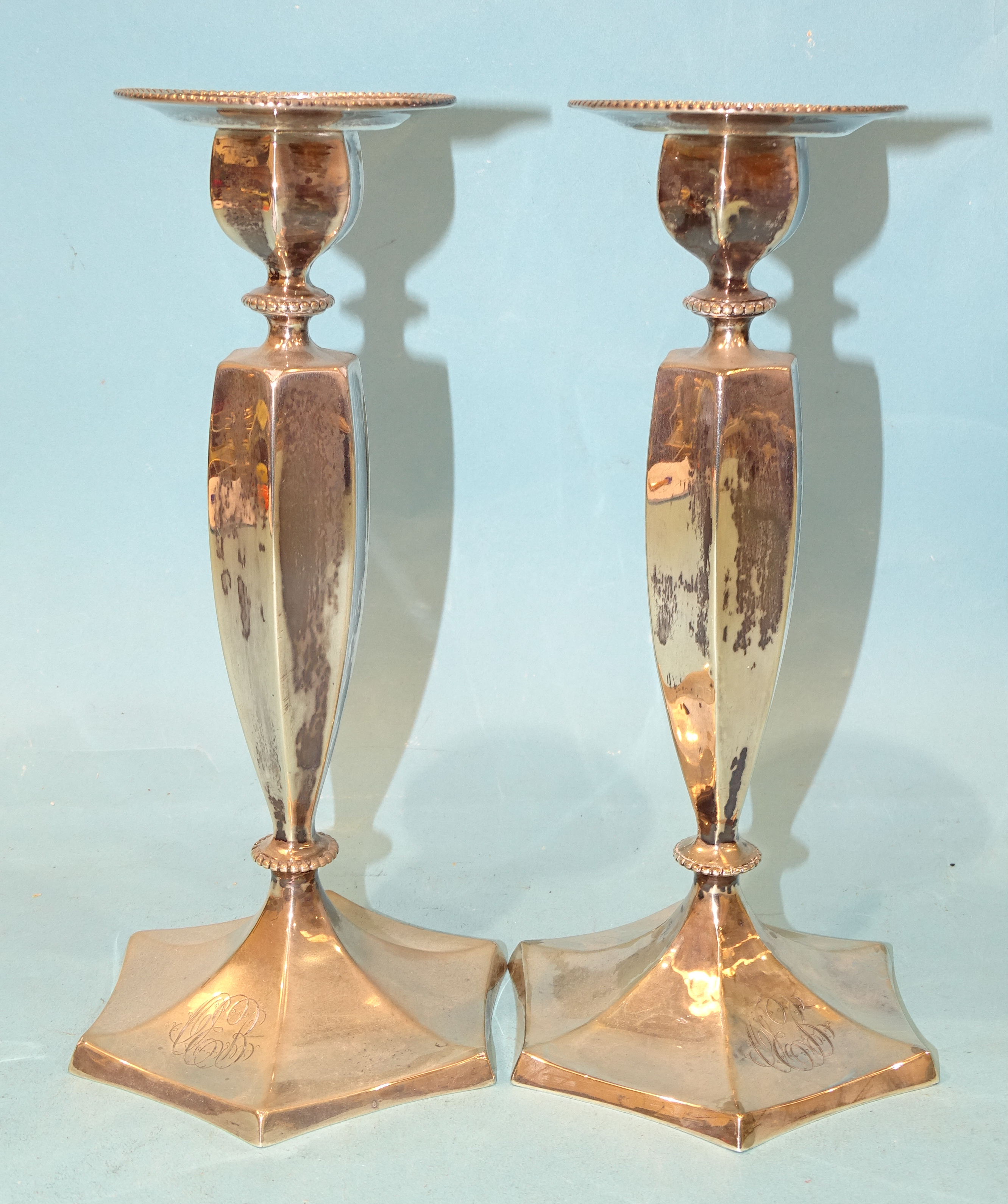 A pair of sterling silver candlesticks of hexagonal tapered form, on hexagonal foot, with engraved